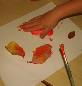 hands painting with leaves 