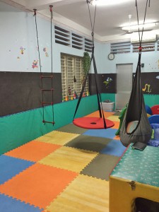 therapy room at an orphanage, showing colorful mats and a suspended swing