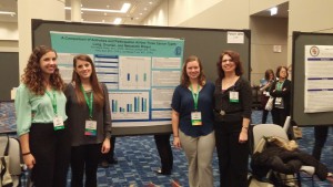 Ann Marie Potter and 3 recent graduates with poster presentation